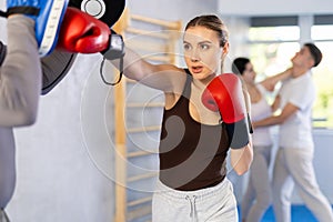 Young woman training in boxing fight in studio