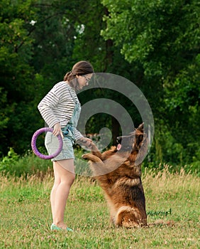 Young Woman training her German Shepherd dog in the park