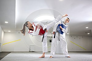 Young woman training martial art of taekwondo with her coach photo