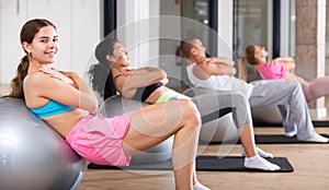 Young woman training pilates at group class