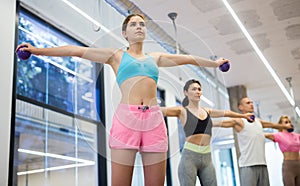 Young woman training pilates with toning balls