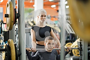 A young woman trains in a gym with a female coach. Deadlift.