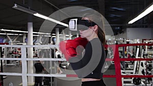 A young woman trains her punches wearing VR glasses - shadow boxing