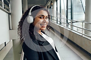 Young woman at the transition zone wearing headphones