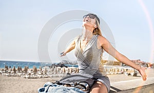 Young woman travel blogger listening music at Los Cristianos beach