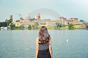 Young woman travel to Europe. Happy Tourist in Mantua looking at cityscape. Cheerful brunette girl traveler enjoy italian landscap