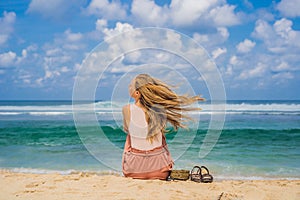 Young woman traveler on amazing Melasti Beach with turquoise water, Bali Island Indonesia