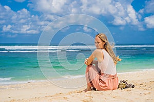 Young woman traveler on amazing Melasti Beach with turquoise water, Bali Island Indonesia