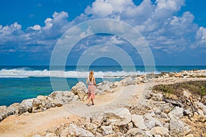 Young woman traveler on amazing Melasti Beach with turquoise water, Bali Island Indonesia