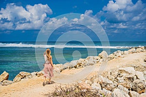 Young woman traveler on amazing Melasti Beach with turquoise water, Bali Island Indonesia