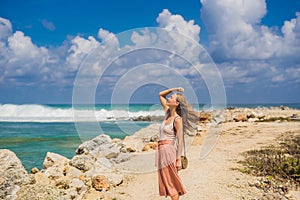 Young woman traveler on amazing Melasti Beach with turquoise water, Bali Island Indonesia