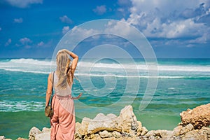 Young woman traveler on amazing Melasti Beach with turquoise water, Bali Island Indonesia