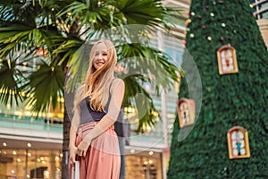 Young woman traveler on the background of Christmas Tree and Palm Trees Decorated in tropical holiday location