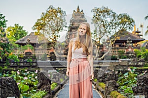 Young woman traveler in the background of Pura Taman Kemuda Saraswati Temple in Ubud, Bali island, Indonesia