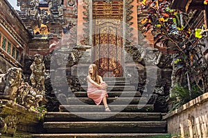 Young woman traveler in the background of Pura Taman Kemuda Saraswati Temple in Ubud, Bali island, Indonesia BANNER