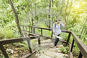 Young Woman Traveler with backpack relaxing outdoor with waterfall and rocky mountains on background Summer vacations.