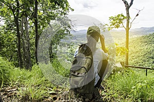 Young Woman Traveler with backpack relaxing outdoor with waterfall and rocky mountains on background Summer vacations.