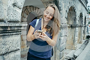 Young woman traveler in a blue T-shirt with backpack looking at