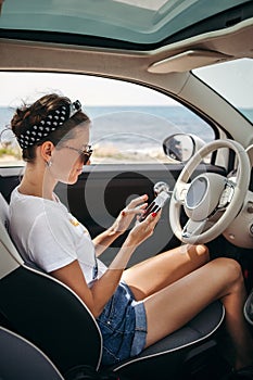 Young woman traveler on car near the sea