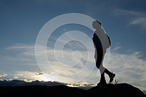 Young Woman Traveler Hiking with Backpack on the Beautiful Rocky Trail at Summer Sunset. Travel and Adventure Concept.