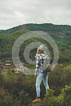 Young woman traveler hiking in the mountains, rear view