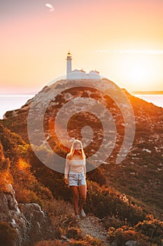 Young woman traveler hiking outdoor   travel healthy lifestyle active vacations girl enjoying sunset lighthouse view
