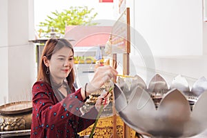 Young woman traveler lighting incense candle fire.