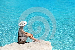 Young woman traveler looking at the sea, travel and active lifestyle concept. Relaxation and vacations concept.