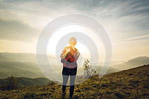 Young Woman Traveler In Red Plaid Shirt With Backpack Climbs Uphill At Sunrise. Scout Travel Adventure Concept