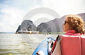 Young woman traveler at sunset ride on kayak - Trip travel concept