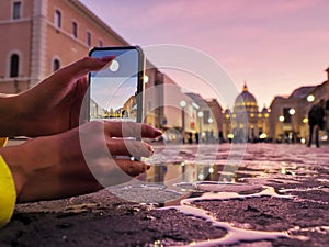 Young woman traveler tourist taking beautiful landscape photo of european sunset during holiday vacation