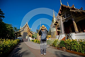 Young woman traveler traveling to Wat Phra Singh temple. This te