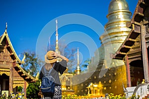 Young woman traveler traveling to Wat Phra Singh temple. This te