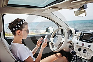 Young woman traveler using phone on car