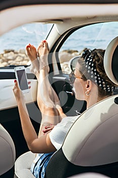 Young woman traveler using phone on car