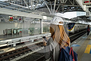 Young woman traveler using travel app in smart phone