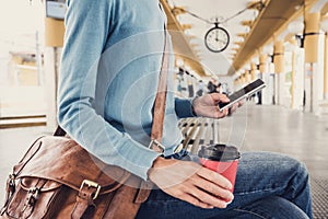 Young woman traveler waiting for a bus on a bus station, travel and active lifestyle concept