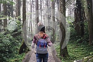 Young woman traveler walking in the forest