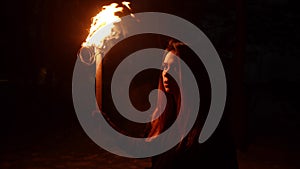 Young woman traveler walking in the woods at night holding a torch