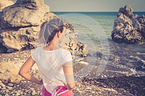 Young woman traveler with white shirt and ponytail stay at beach in Aphrodite bay