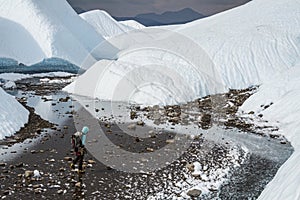 Young woman traveling across a flat rocky valley on the Matanuska Glacier deep in the backcountry of Alaska