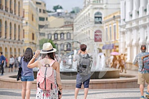 Young Woman traveling backpacker with hat, Asian traveler standing on Senado Square, landmark and popular for tourist attractions photo
