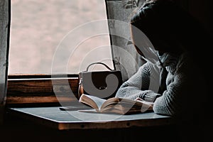 A young woman is traveling by train during coronavirus pandemic and reading