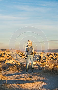 Young woman traveller standing and watching sunrise, Cappadocia, Central Turkey