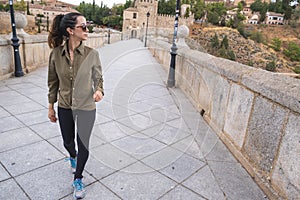 Young woman traveller walking through a bridge during a antumn afternoon