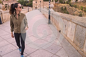Young woman traveller walking through a bridge during a antumn afternoon