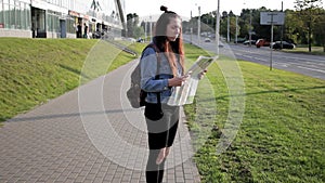 Young woman travels alone in an unfamiliar city, looks at a map