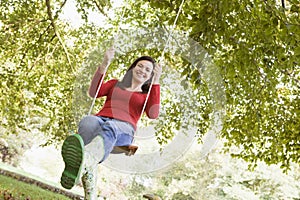 Young woman on tree swing