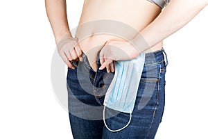 Young woman tries to button tight jeans after quarantine. Consequences of lack of activity and overeating during self-isolation