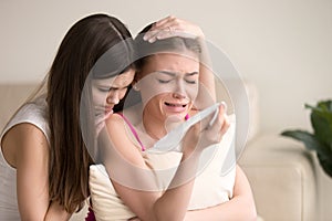 Young woman tries to comfort crying female friend